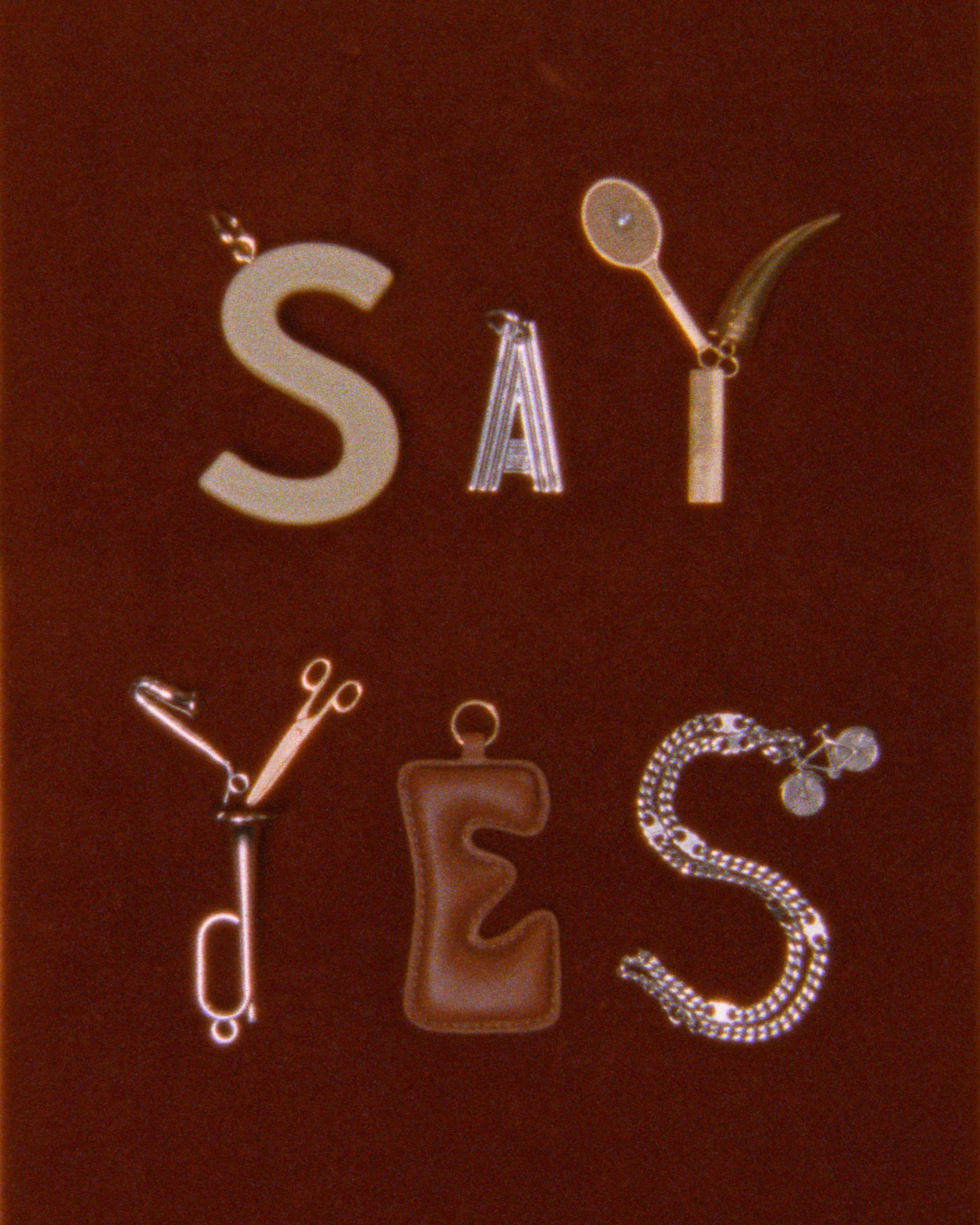 Celine charms spelling out the phrase "Say yes."