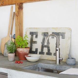 outdoor sink with EAT sign and chopping boards