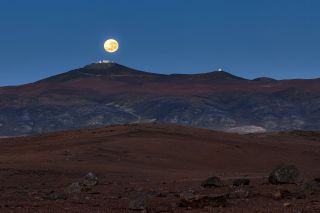 A full moon glows over the Paranal Observatory in the Atacama Desert of northern Chile in this view captured by astrophotographer Gerard Hüdepohl. The observatory is located on top of Cerro Paranal, a mountain with an elevation of 8,500 feet (2,600 meters), and it is home to several telescope facilities. The Very Large Telescope (VLT) array and the VLT Survey Telescope are both visible at the top of the peak in this photo, on the left, and four smaller auxiliary telescopes are on the smaller peak to the right.