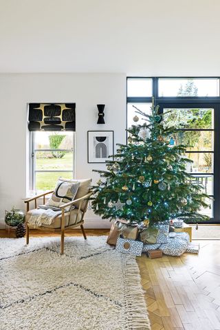 christmas tree in modern living space with white sofas and black accessories