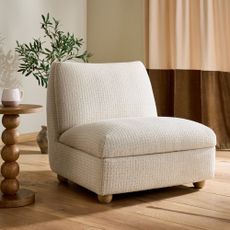 Next Clemmie storage accent chair in oyster in a living room with a bobbin side table next to it