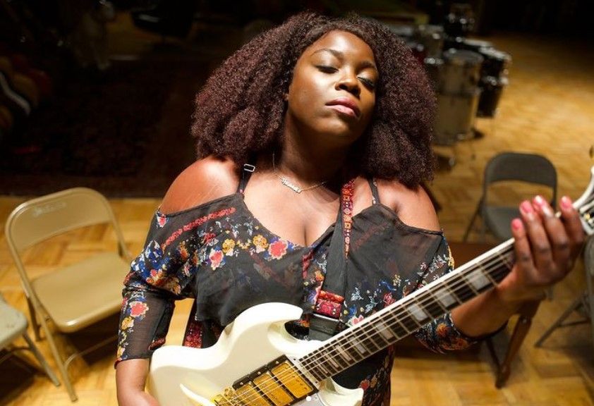 Singer Yola playing a guitar