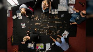 An overhead view of Homo naledi bones laid out by the researchers on a black sheet.