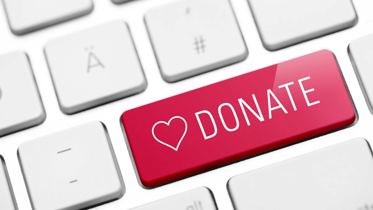 computer keyboard with a red button with a heart and the word &quot;donation&quot; on it