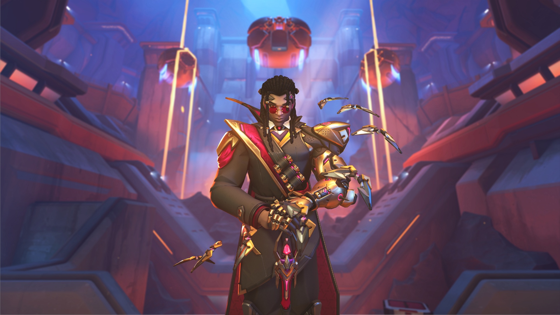 A stern, dark-haired warrior in black, red, and gold armor stands in a glowing sci-fi chamber, holding a weapon as small drones hover nearby.