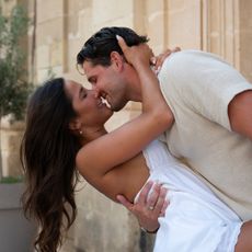 A man (Tim Demirjian) holds a woman (Gia Aldisert) in a dip as they nearly kiss, while standing in a Malta street. A still from the Hulu reality show 'Love Overboard.'