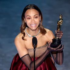 Zoe Saldaña accepts the award for Best Supporting Actress at the 2025 Oscars.