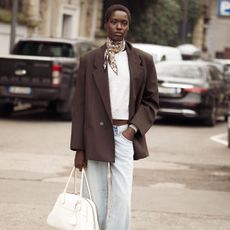street style shot of woman wearing brown blazer and silk scarf