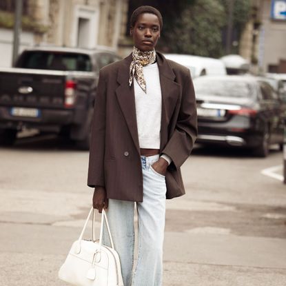 street style shot of woman wearing brown blazer and silk scarf