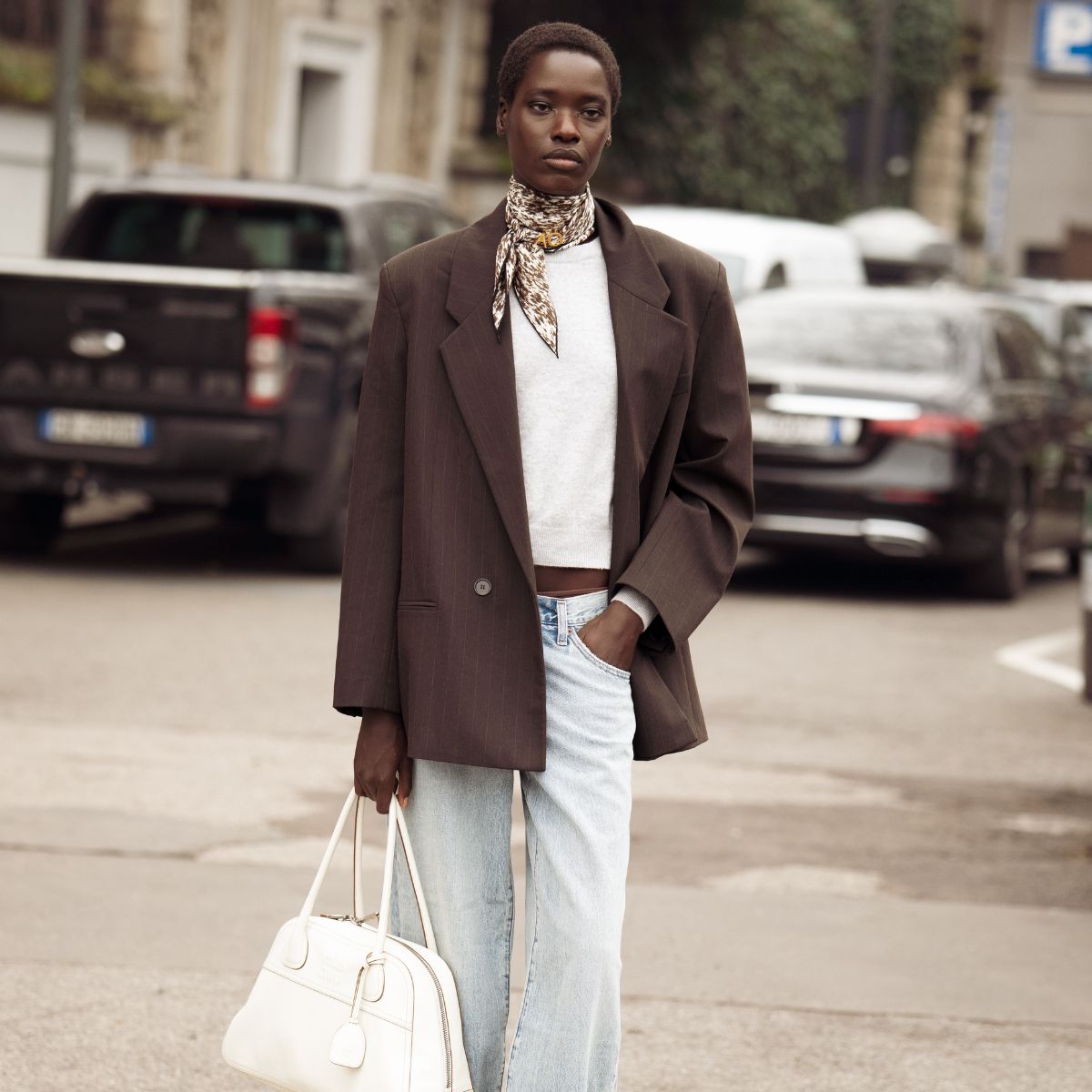 street style shot of woman wearing brown blazer and silk scarf