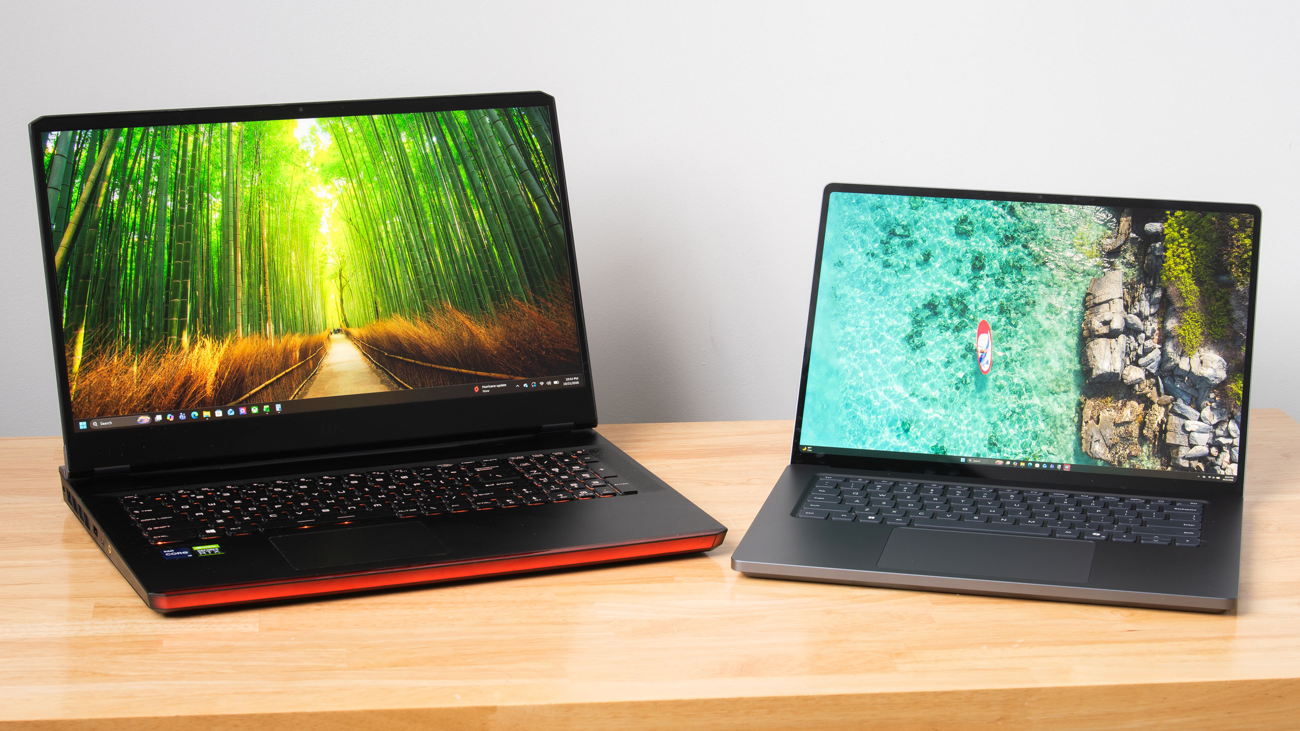 A large gaming laptop next to a smaller, thinner creator laptop