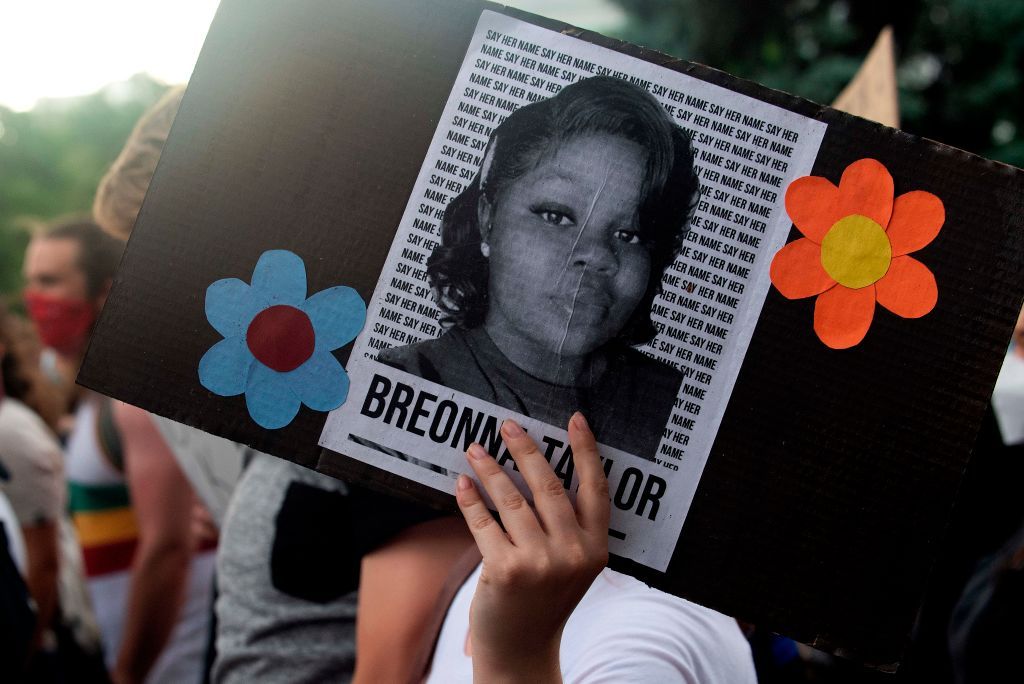 A protester holds a sign with Breonna Taylor&amp;#039;s picture.