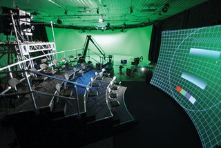 Trumball studios: This image shows the Tørus screen and Christie projector in the foreground with the virtual production green screen stage behind