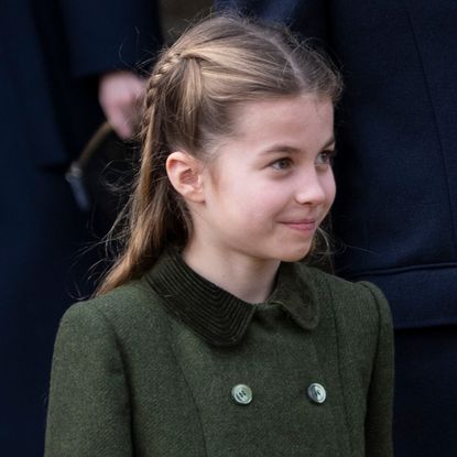 Princess Charlotte wearing a green coat and smiling 