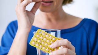 woman taking estrogen replacement therapy pills