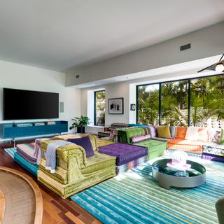 A TV room with a large multicoloured modular sofa