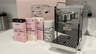 picture of the coffee machine with three different types of pod and limited edition tin