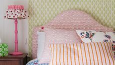 Easy small bedroom DIY projects are so useful. Here is a bedroom with yellow walls and a pink bed with purple, blue, and orange bedding