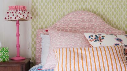 Easy small bedroom DIY projects are so useful. Here is a bedroom with yellow walls and a pink bed with purple, blue, and orange bedding
