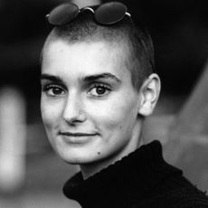 Sinead O'Connor performing on stage with a guitar in 1988