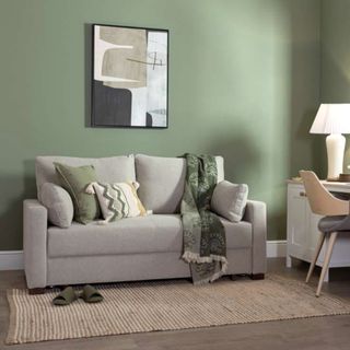 A grey sofa bed in a green living room
