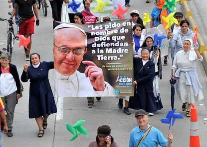 Nuns plead for a climate agreement in Paris, carrying a banner of Pope Francis