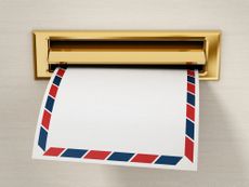 A white envelope is being delivered through a mail slot.