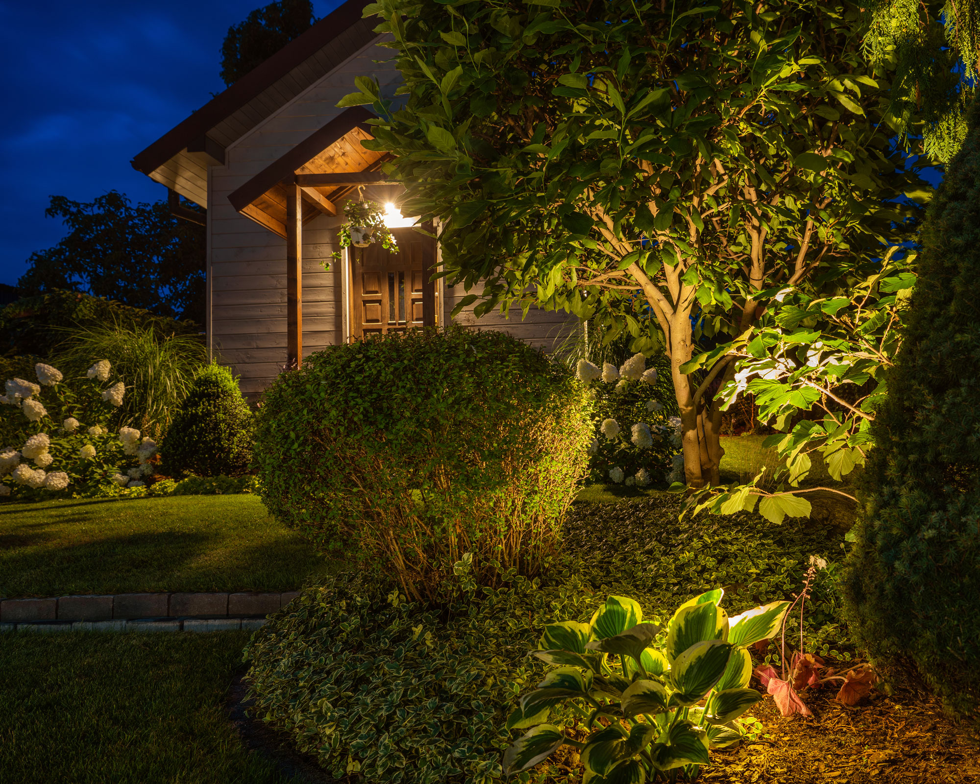 night garden and porch with planting, trees and lawn, and lighting ideas