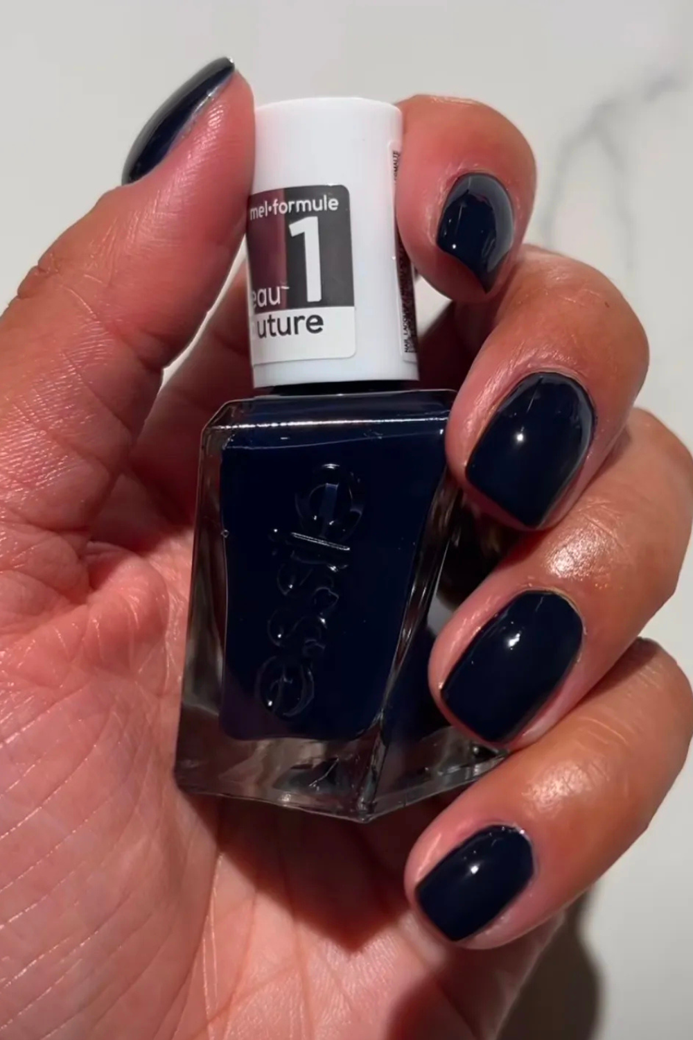 Iram Shelton's hands painted with Essie Caviar Bar nail polish