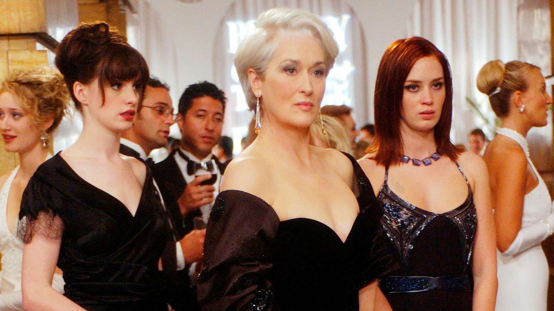 Andy and Emily stand behind Miranda at the Runway fashion party