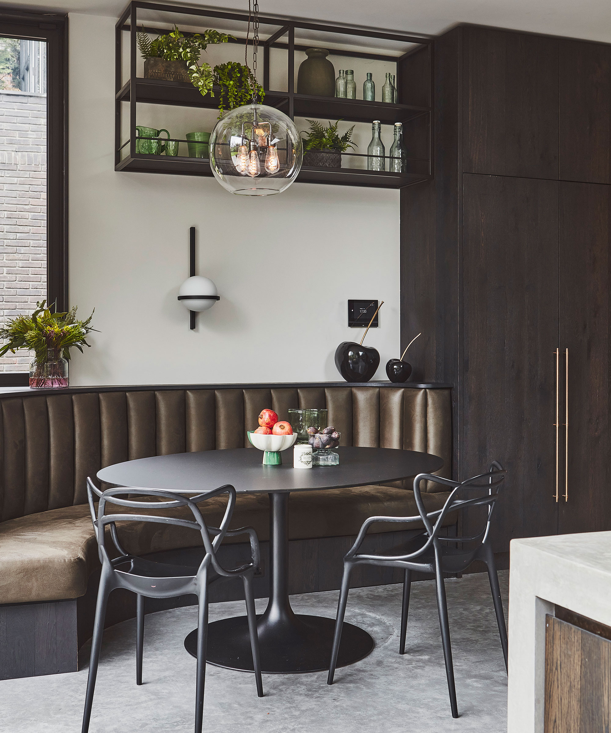 curved banquette seating with round black table and chairs