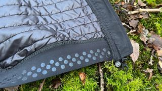 Closeup of bottom section of cycling jacket lying on mossy ground
