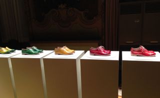 A colourful selection of men's leather shoes displayed on podiums