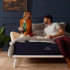 A happy couple on a Dreamcloud mattress and bed