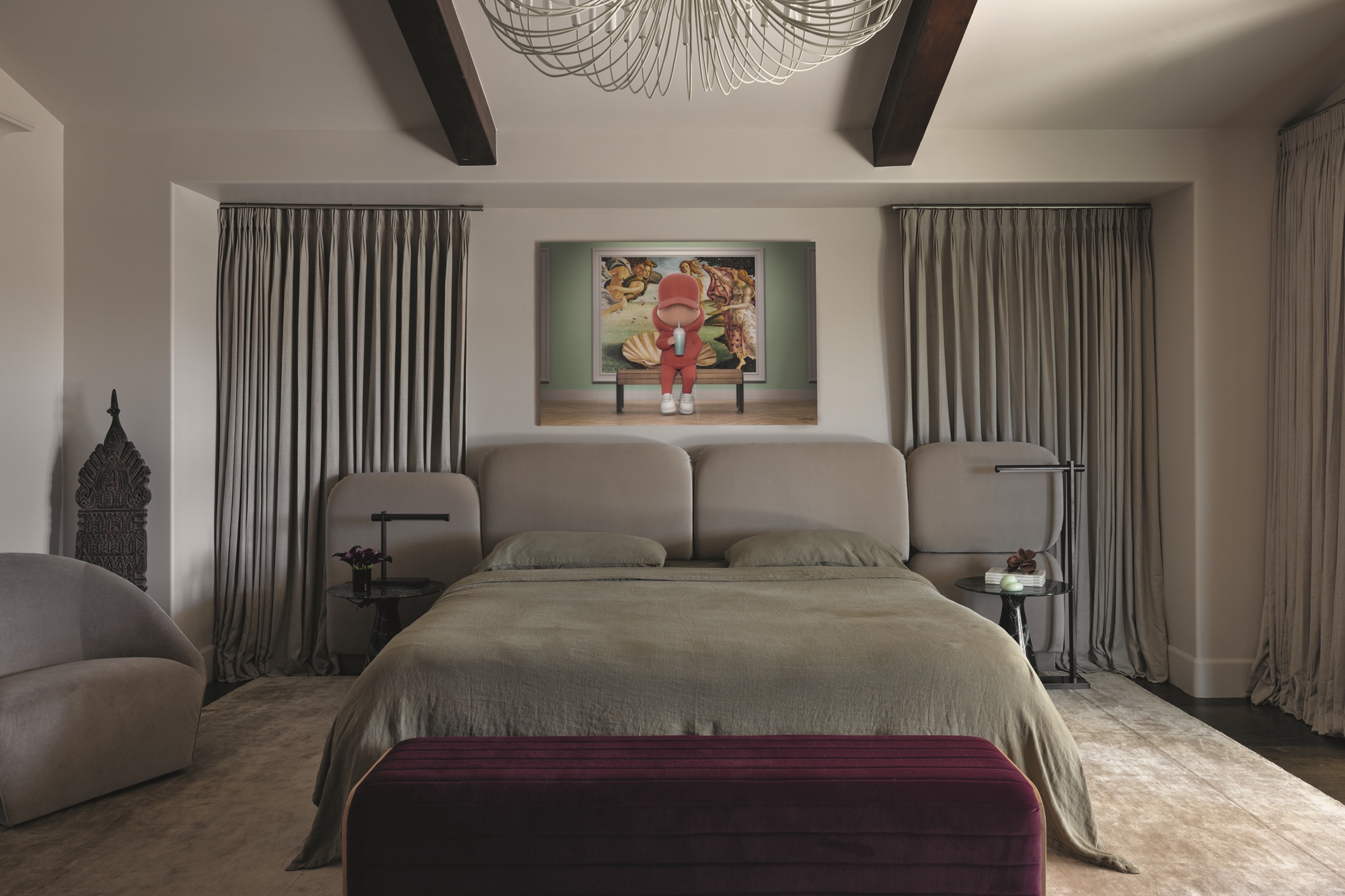 modern bedroom with beige walls, ceiling beams, modern chandelier, artwork hanging above bed, curtains on either side of the bed, burgundy ottoman at the foot of the bed, gray-green bed linen, gray bedhead, beige rug, gray sofa, and heavy drapes