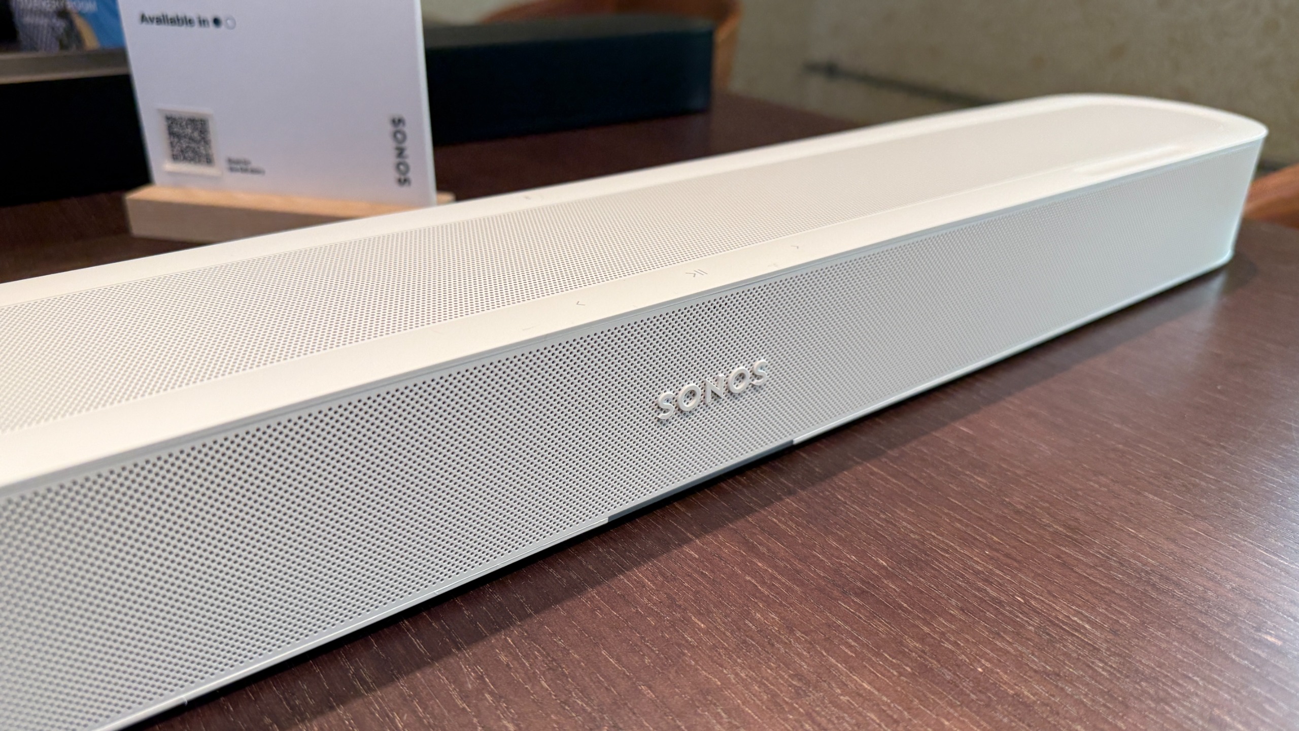 The Sonos Beam Ultra on a wooden table showing its logo