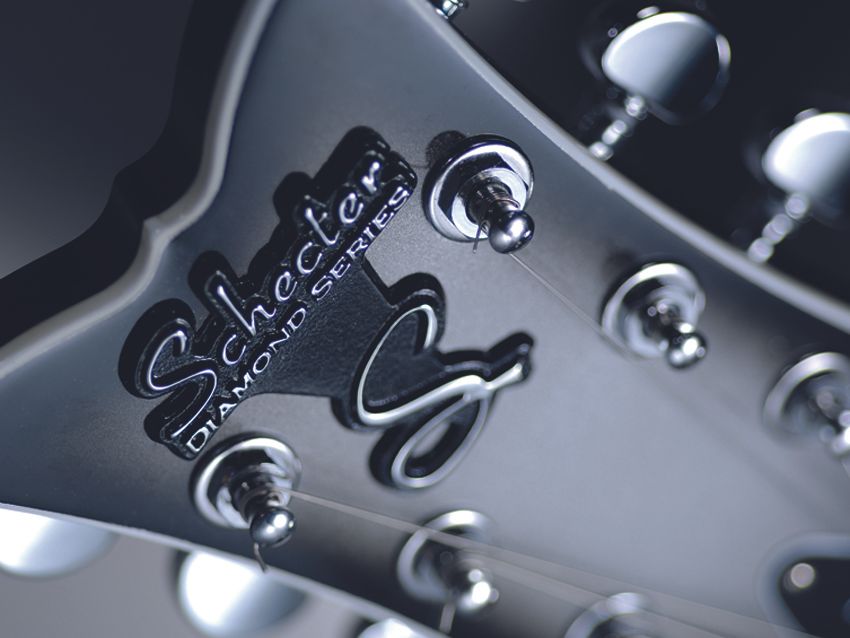 Fishtail headstock with raised metal logo.