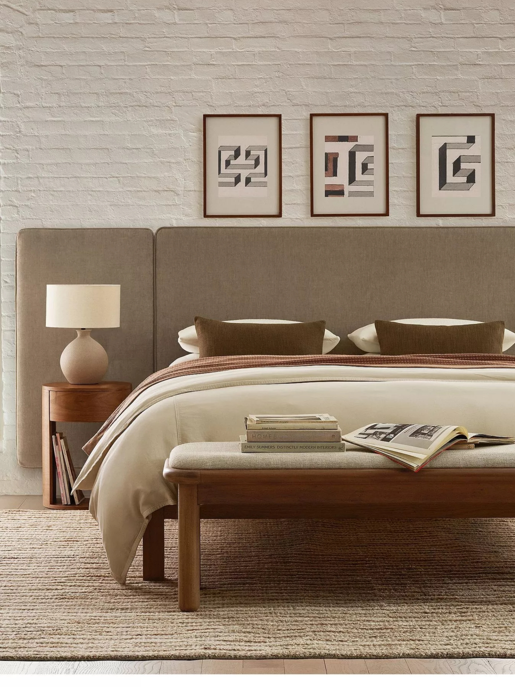 a neutral bedroom with neutral sheets and an oversized headboard