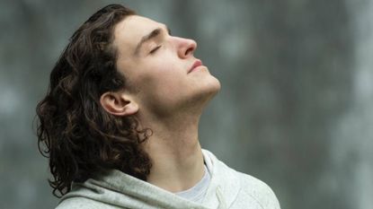 Man breathing deeply outside, sleep & wellness tips