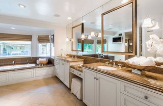 bathroom with white drawers and large mirrors