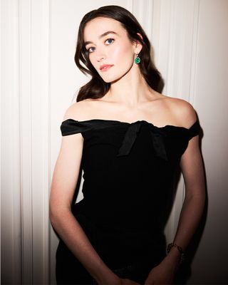 Sarah Pidgeon wears black off-the-shoulder Balenciaga dress with bow detailing and emerald Fred Leighton earrings.