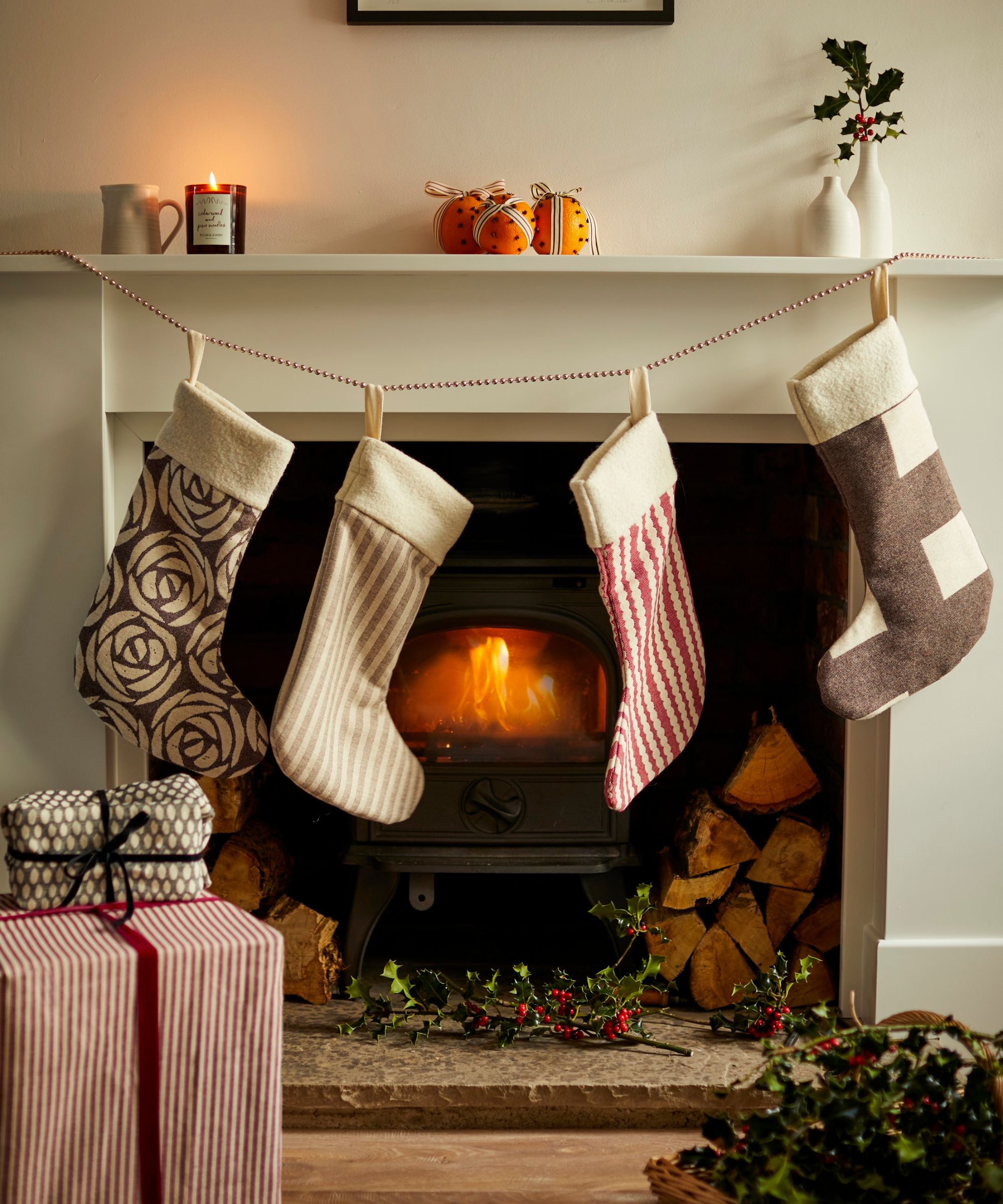 A lit fireplace with traditional Christmas stockings hung across the white mantel.