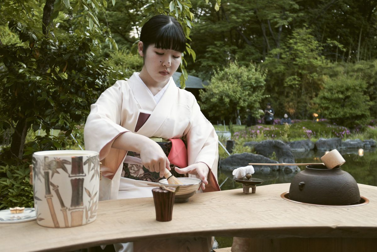 Sample image taken with the Panasonic Lumix L10; lady in a traditional Japan ware in attractive garden with pond, making matcha tea