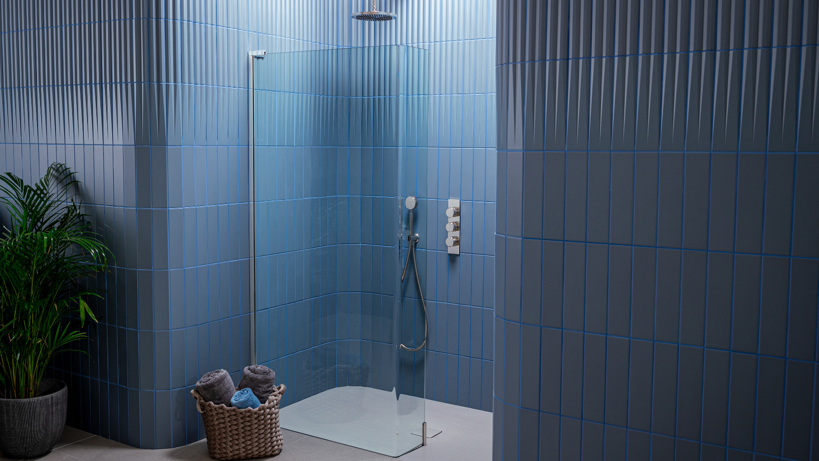 Wet room with blue tiles on the walls and a plant on the left side of the room