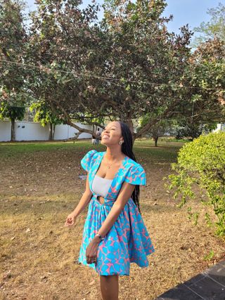 Efua Claire Jobi-Taiwo smiling in a blue and pink patterned dress.