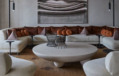 A living room with a grey couch and colorful pillows