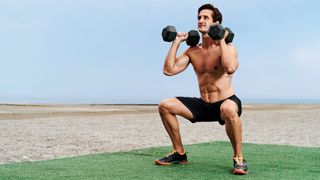 Man doing a squat with two dumbbells 
