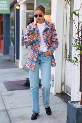 Gigi Hadid wearing a plaid shirt and jeans