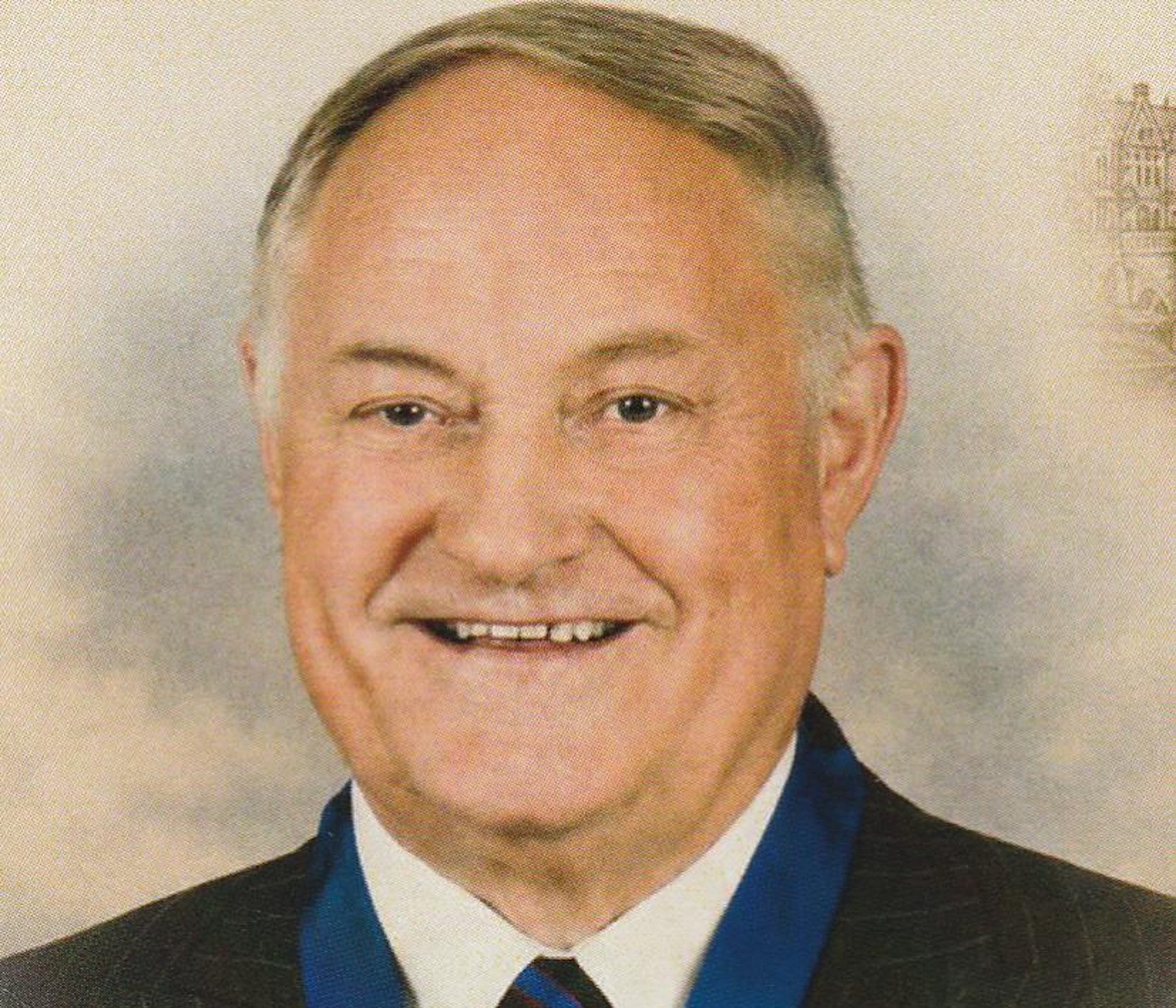 John Featherstone, wearing a suit and smiling at the camera