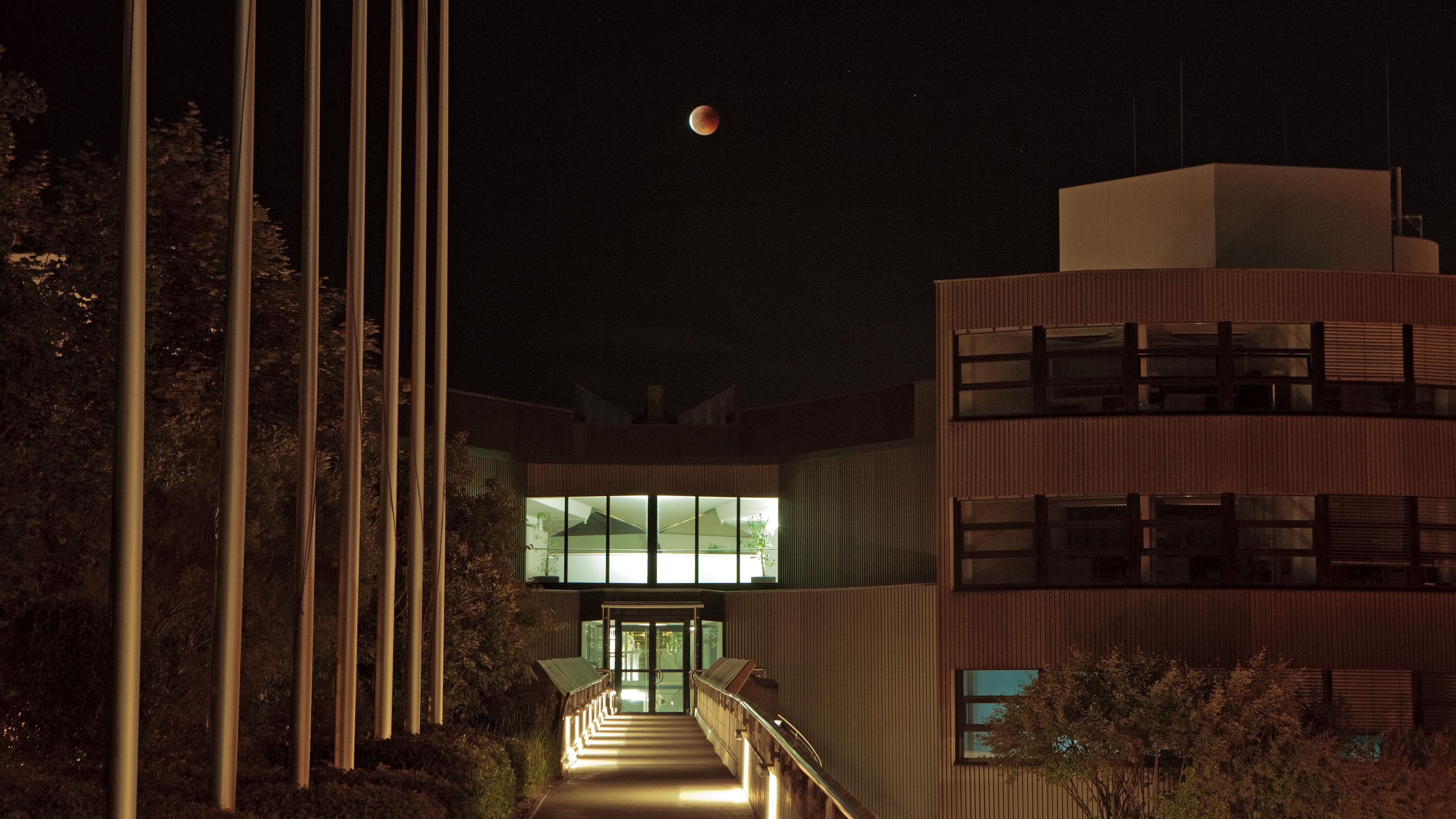 A blood-red moon above a building.